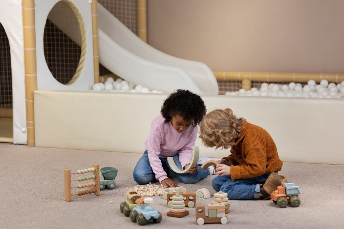 Children playing with different toys in a playroom.