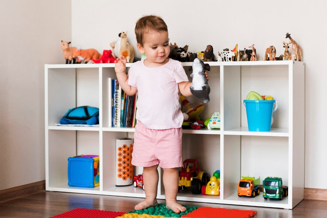 Child playing in front of his toy shelf.