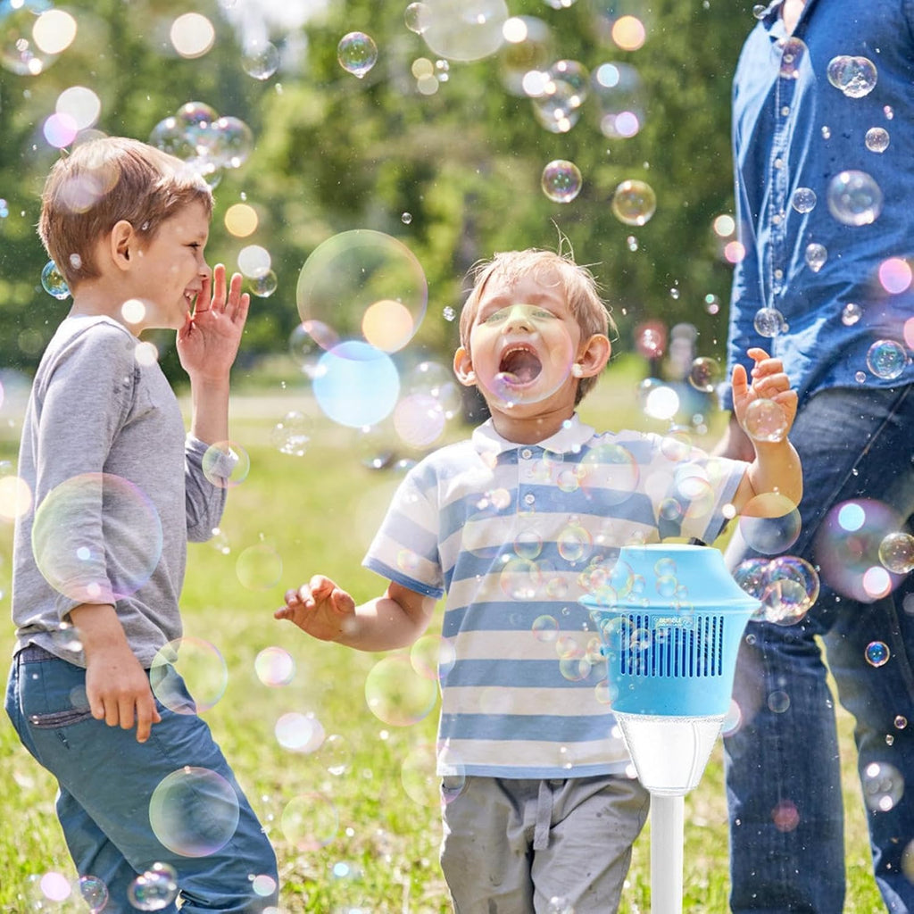 Children playing joyfully outdoors surrounded by colorful bubbles, with a blue automatic bubble machine creating a magical and fun atmosphere.