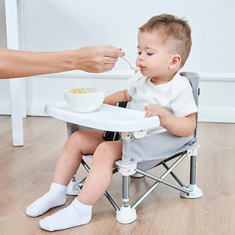 Mother feeding her son, who is sitting comfortably in his GoSit Junior Chair.