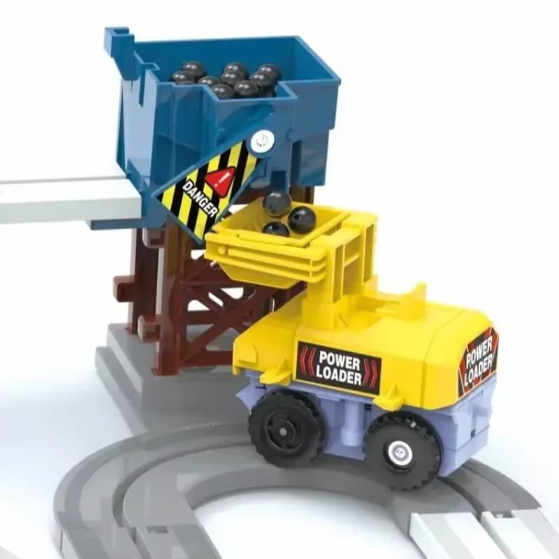 A yellow toy truck labeled "POWER LOADER" collecting black balls from a blue container on an elevated track, with construction warning signs.