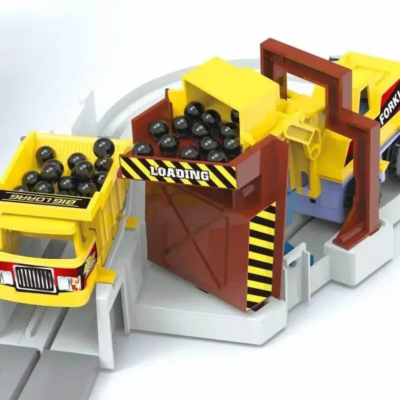 A toy loading station with a yellow dump truck and a conveyor system labeled "LOADING," transferring black balls in a miniature construction play environment.