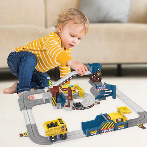 Little boy playing with Junior Construction Site toy that features construction vehicles, a truck, machines, and tracks. 