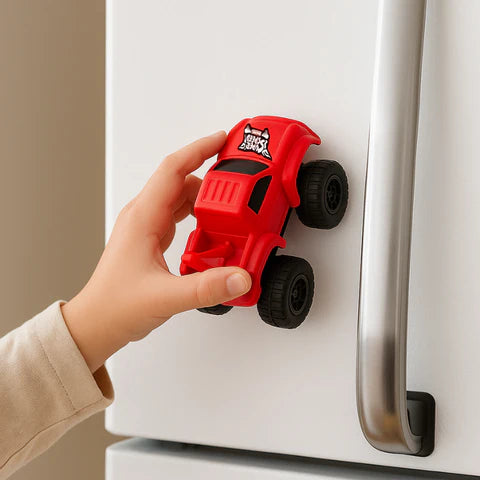 Boy playing with a magnetic racing toy by placing it on fridge to go upwards.