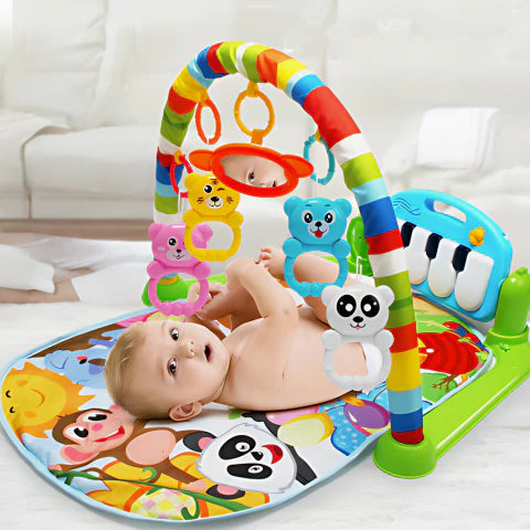 Baby laying in a colorful Music Wonder Mat with a piano, mobile toys hanging from an arch, and a soft mat with animal graphics below.