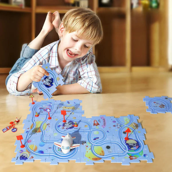 Boy smiling and playing with a Puzzle Track Set. 