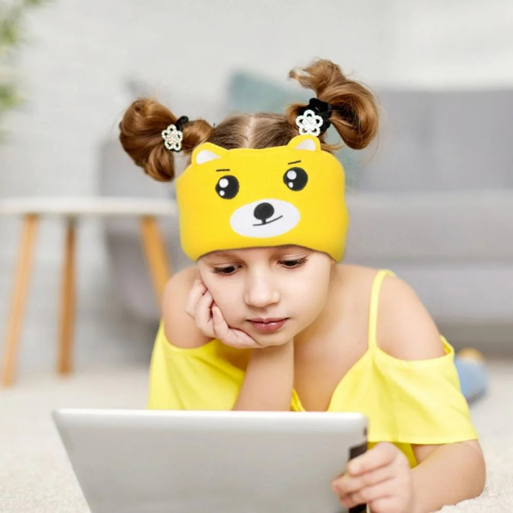 Girl watching cartoons on a tablet while wearing Bear SnuggleSounds headphones.